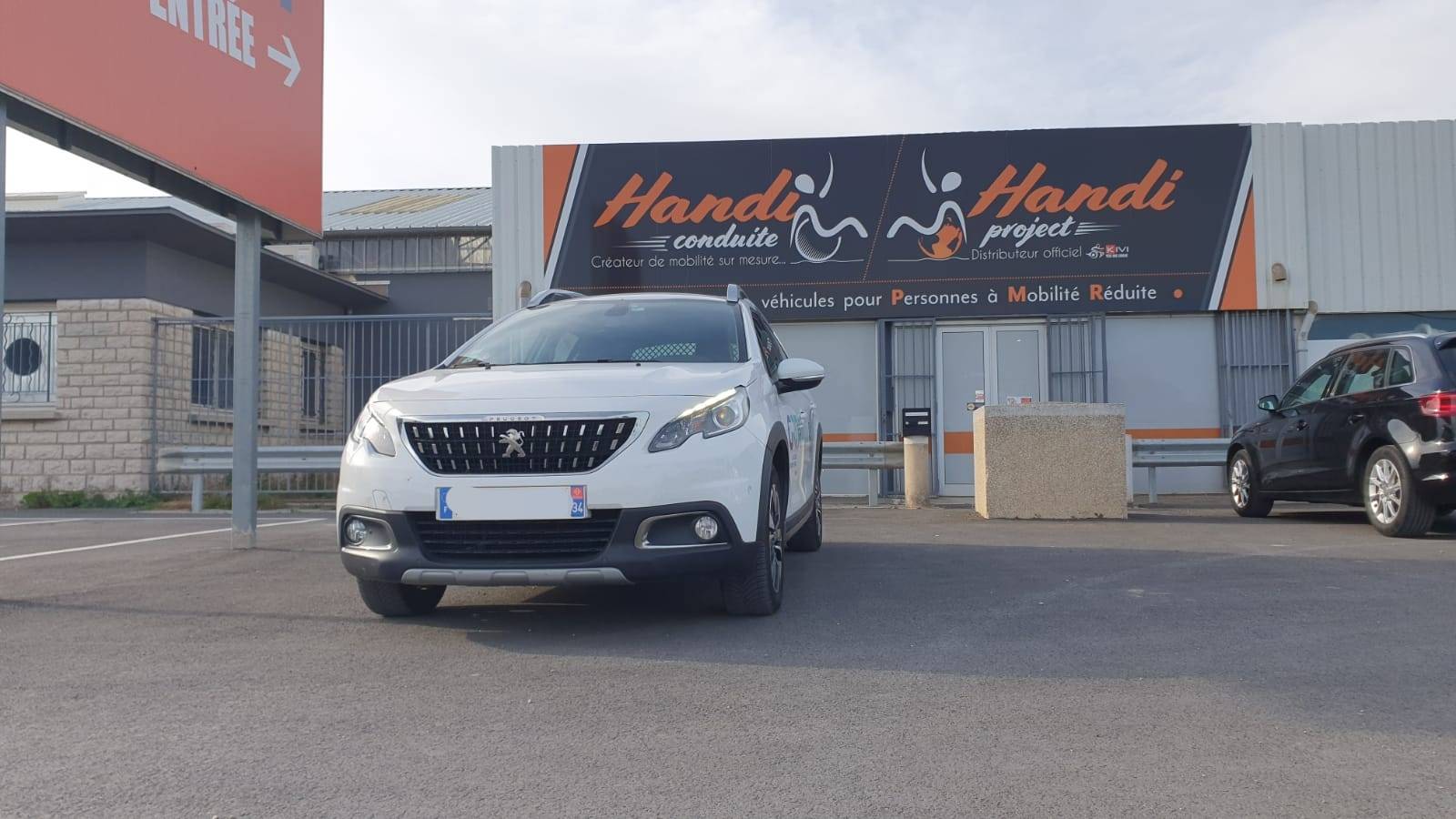 Peugeot 2008 adaptée pour la conduite d'une personne handicapée avec télécommande multifonctions au volant dans l'Hérault par Handi Conduite
