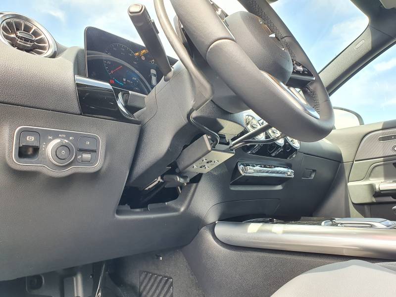 Aménagement au poste de conduite d'un accélérateur par cercle sous volant à tirer et levier de frein manuel à baisser sur Mercedes GLA par Handi Conduite dans l'Hérault