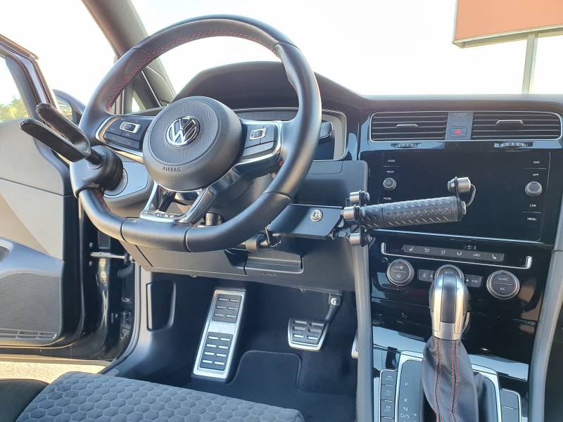Baisser pousser au volant pour accélérer et freiner en conduite tétra sur une Golf 7, adaptation d'un harnais de maintien 3 points, une solution d'aide à la conduite tétra proposée par Handi Conduite dans l'Hérault à Montpellier
