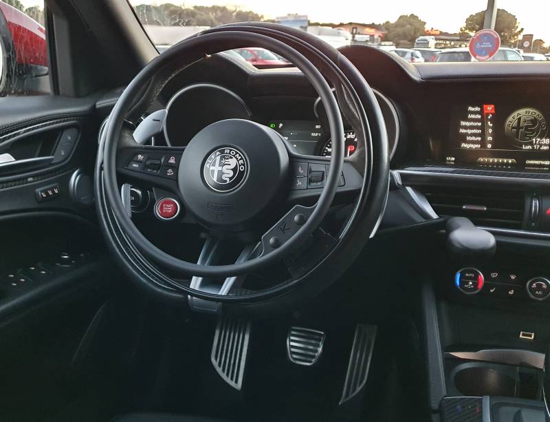 Aide à la conduite personne paraplégique sur une Alfa Roméo Stelvio, aménagements de conduite PMR cercle accélérateur sur volant amovible KS Wireless et levier de frein manuel à baisser Lf 901 de Handi Conduite à Montpellier