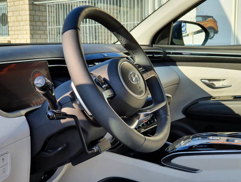 Volant adapté PMR avec accélérateur par manettes électroniques et levier de frein pour la conduite par une personne handicapée d'une Hyundai Tucson Hybride sur Montpellier Hérault Handi Conduite