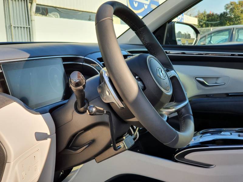 Adaptation PMR au volant avec accélérateur par manettes électroniques et levier de frein à baisser pour une conduite paraplégique sur Hyundai Tucson Hybride dans l'Hérault à Montpellier par Handi Conduite
