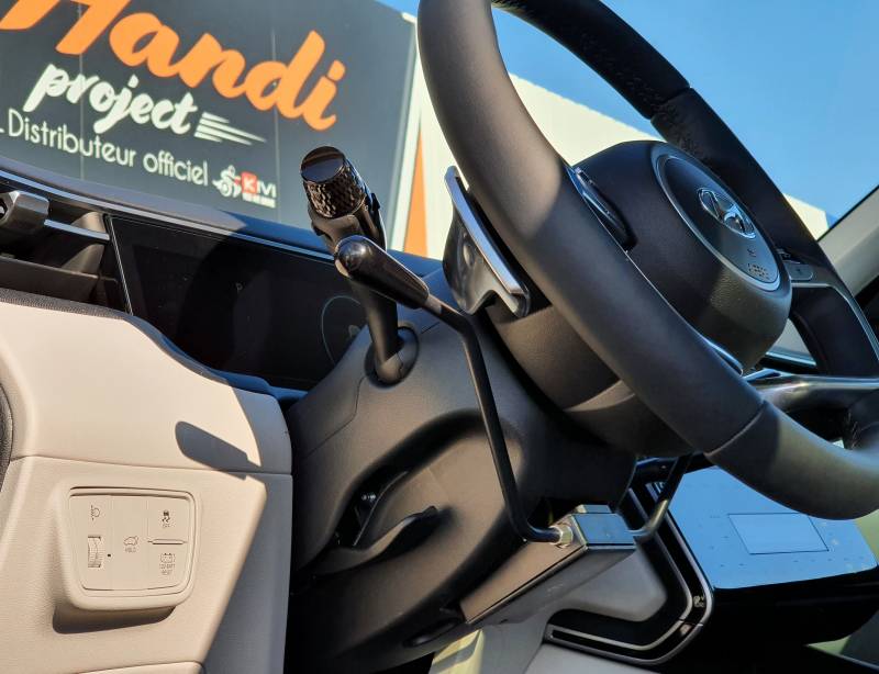 Adaptation conduite paraplégique avec accélérateur par manettes électroniques  au volant et levier de frein à Montpellier sur Hyundai Tucson Hybride par Handi Conduite