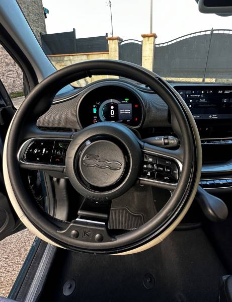 A vendre véhicule PMR Fiat 500E 9350km pour 33 990€, cercle accélérateur sur volant amovible et levier de frein pour conduite PMR au volant. une vente à saisir par Handi Conduite