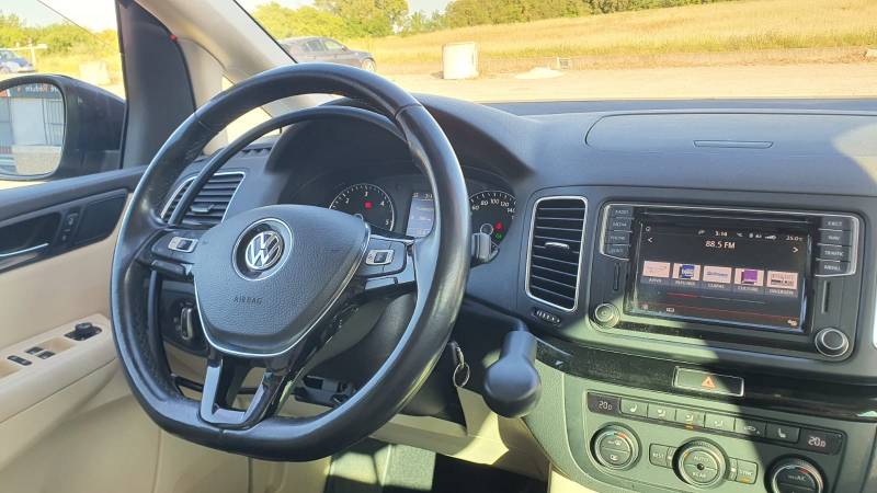 Poste de conduite aménagé pour une personne paraplégique avec un accélérateur par cercle installé sous le volant et un levier de frein manuel à baisser à droite du volant sur un Volkswagen Sharan, une adaptation Handi Conduite