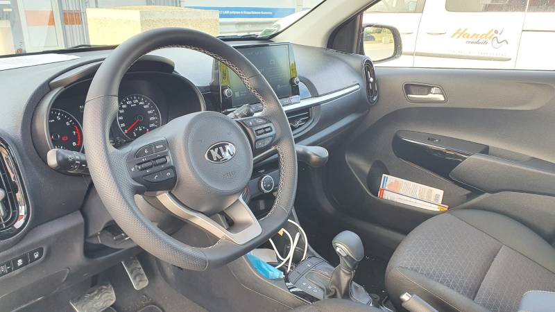 Levier de frein manuel à baisser adapté sur le poste de conduite d'une Kia Picanto pour la conduite par une personne handicapée dans l'Hérault, à Montpellier par Handi Conduite