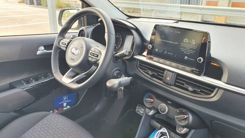 Poste de conduite aménagé sur la Kia Picanto d'une personne handicapée avec un levier de frein manuel à baisser, par Handi Conduite à Montpellier