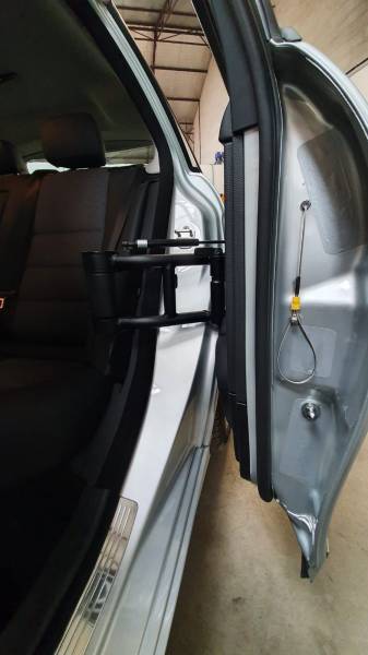 Chargement de fauteuil roulant avec aménagement d'une porte escamotable arrière gauche sur une Mercedes pour conduite tétra par Handi Conduite dans l'Hérault